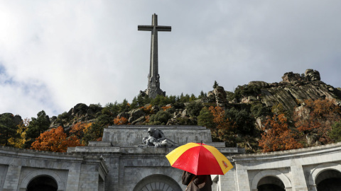 Una mujer con un paraguas con los colores de la bandera española, en el Valle de los Caídos. REUTERS/Susana Vera