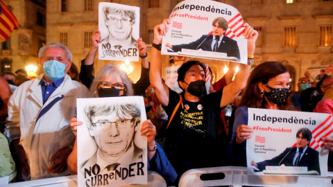 Varias personas sostienen retratos del expresidente de la Generalitat Carles Puigdemont durante las fiestas de la Mercé, de Barcelona. EFE/Marta Pérez