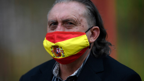  Una persona con una mascarilla con una bandera española asiste a la reunión de clausura de campaña del Partido Socialista Español (PSOE) para las pasadas elecciones regionales de Madrid, en Madrid el 2 de mayo de 2021.- AFP