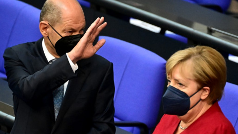  El ganador de las recientes elecciones Olaf Scholz junto a Angela Merkel antes de una sesión plenaria en el Bundestag el 25 de agosto. 2021.-Tobias SCHWARZ / AFP