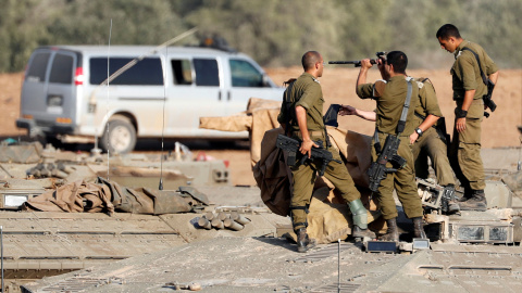 Los soldados israelíes revisan sus armas encima de un vehículo blindado de transporte de personal cerca de la frontera con Gaza, en el sur de Israel. REUTERS / Ronen Zvulun