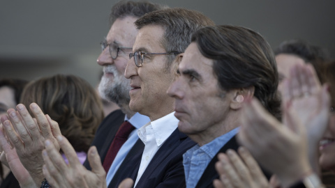 El presidente del PP, Alberto Núñez Feijóo, flanqueado por dos de sus predecesores, Mariano Rajoy y José María Aznar, aplauden durante la clausura de la 26 Intermunicipal del partido, en Valencia, en febrero de 2023. E.P./Jorge Gil