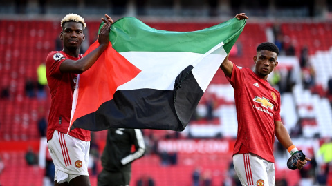  Paul Pogba y Amad Diallo sostienen la bandera de Palestina tras jugar un partido con el Manchester United en la Premier League inglesa en mayo de 2021.- Laurence Griffiths/PA Wire/dpa