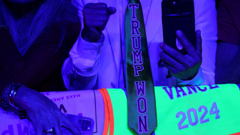 Un seguidor de Donald Trump con una corbata que lleva estampado el lema 'Trump Gana', durante el seguimiento de la noche electoral en el Palm Beach County Convention Center, en West Palm Beach (Florida, EEUU). REUTERS/Brian Snyder