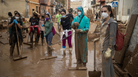  Voluntarios con palas y cepillos retiran barro de las calles del barrio de El Raval.Alejandro Martínez Vélez / Europa Press