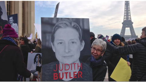 La historiadora Joan Scott sostiene una pancarta con el rostro de la filósofa Judith Butler en una manifestación en París. Imagen de archivo.