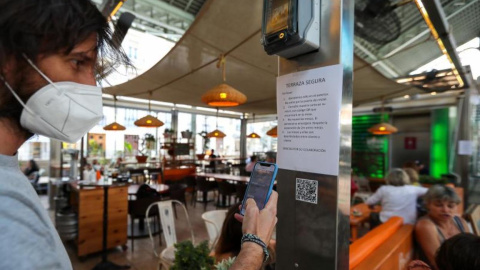 Un joven consulta la carta de productos con código QR en un bar / EFE