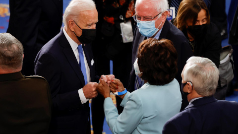 El presidente de los Estados Unidos, Joe Biden, saluda con el puño a la representante Maxine Waters mientras el senador Bernie Sanders observa tras el discurso del primero en la sesión conjunta del Congreso de los Estados Unidos en el Capitolio en Washi