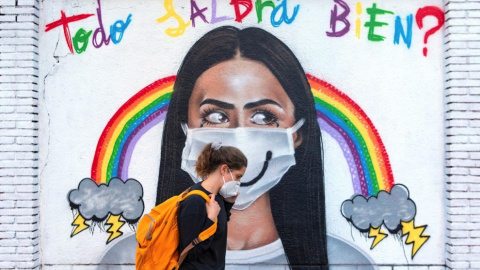  Una mujer pasea frente a un mural sobre la pandemia por covid-19. — EFE / ARCHIVO