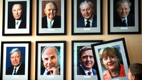  La imagen de la canciller alemana Angela Merkel está colgada en una pared con los retratos de los ex cancilleres alemanes (arriba, de izquierda a derecha) Konrad Adenauer, Ludwig Erhard, Kurt Georg Kiesinger, Willy Brandt, (abajo, de izquierda a derecha