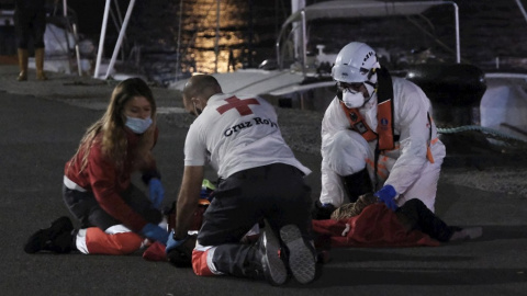 Dos voluntarios de Cruz Roja y un tripulante de Salvamento marítimo intentan reaniman a la niña que llegó sin pulso al muelle de Arguineguín (Gran Canaria) el pasado miércoles.- Ángel Medina G. / EFE