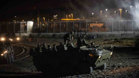  Un blindado del Ejército de Tierra maniobra en la playa del Tarajal para evitar la entrada de marroquíes que se lanzan para cruzar nadando la frontera.- JAIRO VARGAS