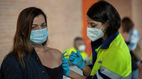  Una enfermera del servicio murciano de salud administra la tercera dosis de la vacuna covid a una mujer este lunes en el Palacio de los Deportes de Murcia. - EFE