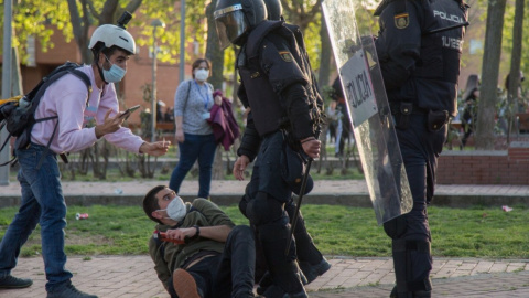 El periodista Guillermo Martínez, en el suelo junto a dos policías antidisturbios, el 7 de abril de 2021, día del mitin de Vox en Vallecas. – Fernando Capdepón Arroyo