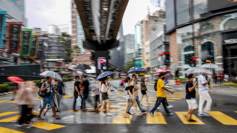 Los peatones con paraguas cruzan una intersección durante la lluvia cerca de los distritos comerciales de Kuala Lumpur (Malasia), a 15 de octubre de 2022. Foto: Wong Fok Loy / SOPA Images via ZUM / DPA