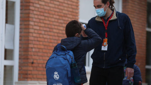  Un trabajador toma la temperatura a un niño a su llegada a clase presencial.- Isabel Infantes / Europa Press