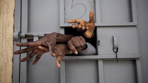 Siete migrantes subsaharianos sacan las manos por la ventana de una celdaen el Centro de Detención de Garabuli, suplicando agua, cigarros, comida y su liberación /Narciso Contreras