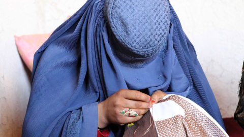  Una mujer afgana trabaja bordando ropa en un taller en Kandahar, Afganistán..- EFE