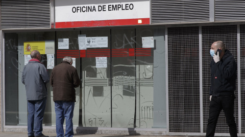 Dos ancianos leen los carteles de una oficina de empleo cerrada durante el primer día laborable desde que se decretó el estado de alarma, en Alcorcón (Madrid). E.P./Eduardo Parra