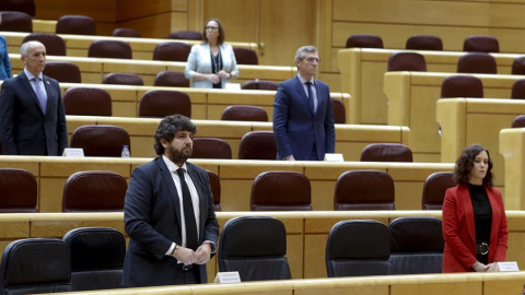 La presidenta de la Comunidad de Madrid, Isabel Díaz Ayuso (d) y su homólogo de Murcia, Fernando López Miras (i) guardan un minuto de silencio por las víctimas del coronavirus durante la sesión de la Comisión General de Comunidades Autónomas celebr