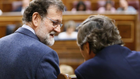 El presidente del Gobierno, Mariano Rajoy (i), conversa hoy con el portavoz del Partido Popular en el Congreso de los Diputados, Rafael Hernando, durante el pleno de hoy en la Cámara Baja, en el que se ha aprobado el real decreto ley de reforma de la est