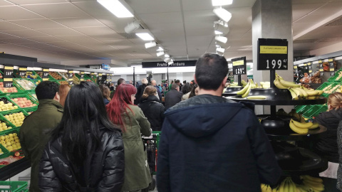 Decenas de personas esperan a pagar su compra en un supermercado en Madrid. EFE/Juan Vargas