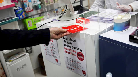 13/05/2020.- Un hombre recoge en una farmacia de Madrid este miércoles una de las mascarillas FPP2 que está entregando gratuitamente la Comunidad de Madrid. / EFE - DAVID FERNAÁNDEZ