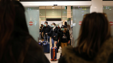 Pasajeros con mascarilla procedentes de Italia llegan al aeropuerto de Barcelona. - REUTERS