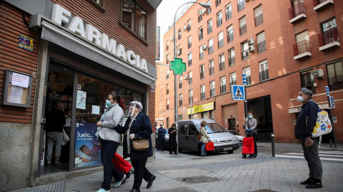 Varias personas hacen cola manteniendo la distancia de seguridad en una farmacia de Madrid. / EFE - DAVID FERNÁNDEZ