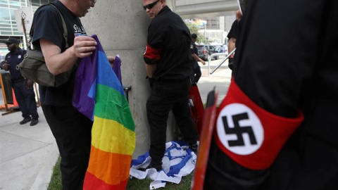 Uno de los asaltantes rasgó una bandera arcoiris y otro orinó en una bandera israelí. Reuters