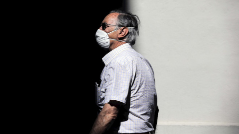 13/05/2020.- Una persona protegida con mascarilla recorre una calle en València, donde se mantiene la fase 0 en el sexagésimo día de estado de alarma. EFE/Ana Escobar