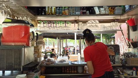 La cambrera del bar-xiringuito Tsunami dels Jardins del Baix Guinardó treballa durant el primer dia amb les terrasses obertes. Maria Rubio