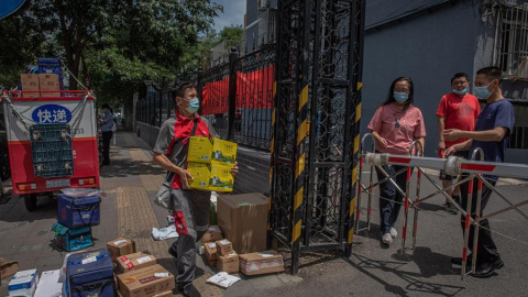 Un repartidor entrega paquetes para los residentes en un complejo residencial cerrado cerca del mercado de Yuquandong, en el distrito de Haidian, Pekín, China. EFE/EPA/ROMAN PILIPEY