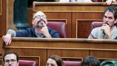 Los diputados de Unidas Podemos Txema Guijarro y Alberto Rodríguez sentados en sus escaños durante la primera sesión del debate de investidura del presidente del Gobierno en funciones en la XIV Legislatura en Madrid (España), a 4 de enero de 2020.