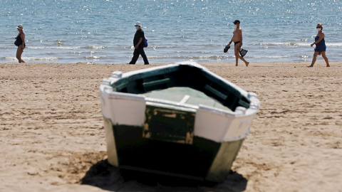 Cuatro personas disfrutan del buen tiempo y del calor en la playa de la Malvarrosa, el pasado viernes. EFE/Kai Försterling