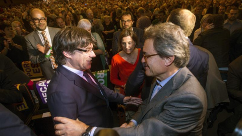 El presidente de la Generalitat Carles Puigdemont, saluda al expresidente Artur Mas en presencia de la presidenta del parlamento catalán, Carme Forcadell. - EFE