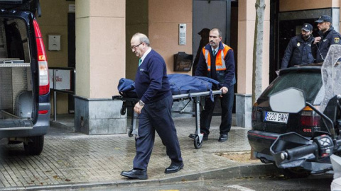 Miembros de los servicios funerarios trasladan los restos mortales de la mujer  fallecida en su piso del barrio de Son Cladera, en Palma. - EFE