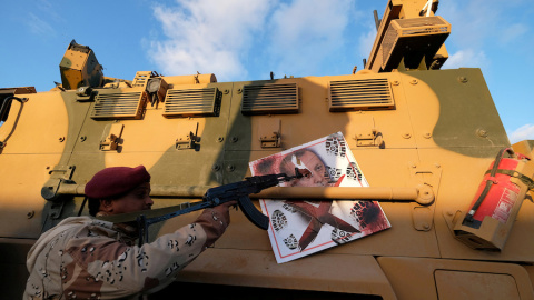 Un miembro del Ejército Nacional de Libia (LNA) comandado por Khalifa Haftar, apunta su arma a la imagen del presidente turco Tayyip Erdogan colgado de un vehículo blindado militar turco en Benghazi, Libia. REUTERS / Esam Omran Al-Fetori