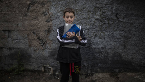 Manuel posa con sus libros para hacer los deberes que le manda el colegio.- BRUNO THEVENIN