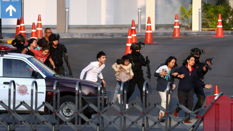 La seguridad tailandesa evacuan a las personas que quedaron atrapadas en el centro comercial después del tiroteo. | Reuters.