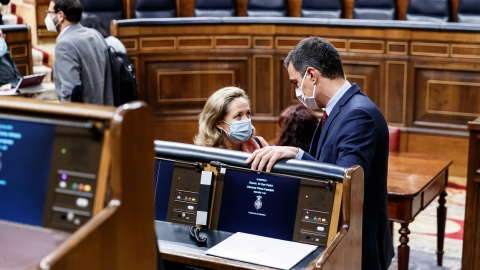 El presidente del Gobierno, Pedro Sánchez, conversa con la vicepresidenta económica, Nadia Calviño, al inicio de la última sesión de control al Ejecutivo bajo el estado de alarma, en el Congreso. E.P.