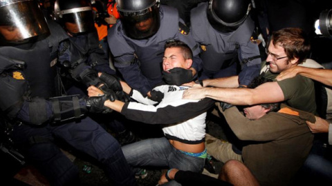 La Polícia trata de detener a uno de los jóvenes | Foto: EFE