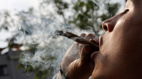 Una persona fuma un porro de Marihuana en México. Un manifestante por la legalización de la marihuana durante una marcha reciente en México. REUTERS/Henry Romero