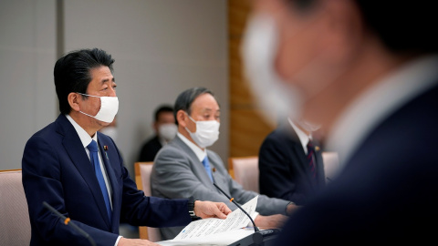 El primer ministro de Japón, Shinzo Abe, con mascarilla, con otros miembros de su gabinete para analizar las medidas frente a la pandemia del coronavirus. REUTERS/Franck Robichon