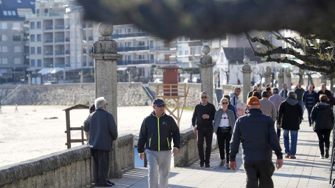 Turistas en el paseo marítimo de Silgar, en la playa de Xanxenxo, que ha recibido estos días a cientos de madrileños. /EFE