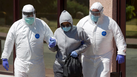 Personal sanitario traslada desde el Centro de Acogida, Emergencia y Derivación de Cruz Roja de Málaga a una de las personas afectadas por la covid-19 al hospital Clínico malagueño. EFE/Daniel Pérez