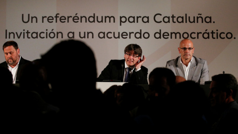 El president del Govern, Carles Puigdemont, entre el vicepresidente de la Generalitat Oriol Junqueras y el conseller Raul Romeva, antes del inicio de su conferencia en Madrid para defender el referendum soberanista. REUTERS/Juan Medina