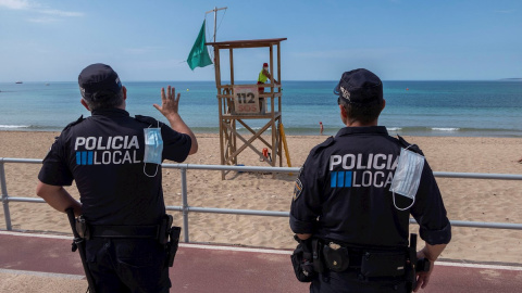 Efectivos policiales vigilan la playa de Can Pere Antoni de Palma. EFE/ CATI CLADERA