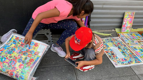 Niños venden juegos de mesa este jueves en una calle del centro histórico de Ciudad de México (México). | EFE