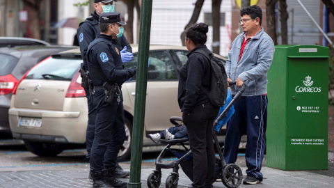 16/03/2020.- Agentes de la policía local de Murcia informan a una familia de que no se puede estar en la calle, debido al estado de alarma decretado por el gobierno, por la crisis del coronavirus, esta tarde en la Ronda de Garay de Murcia. EFE/Marcial Gu